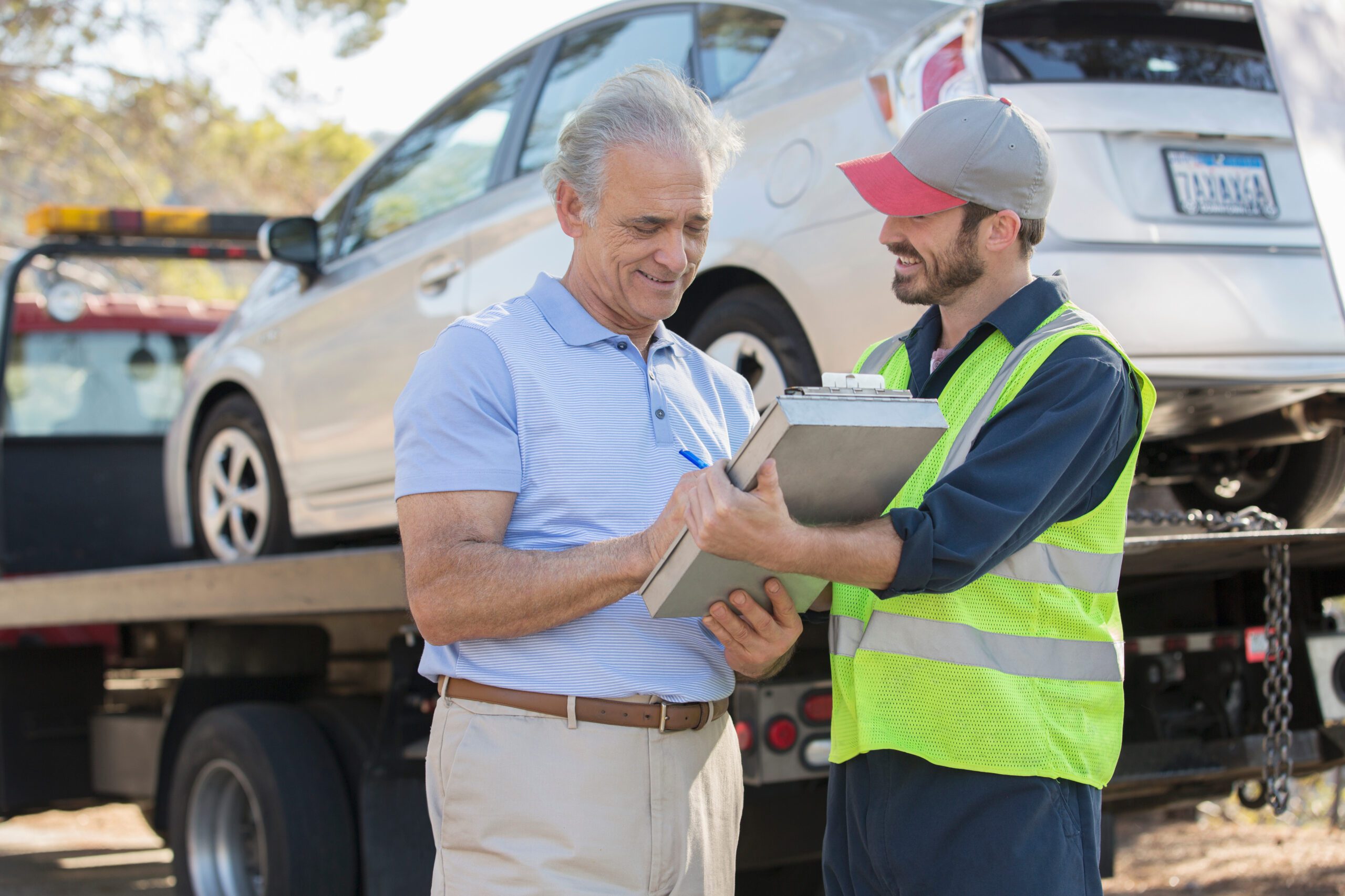 Roadside mechanic and man with paperwork